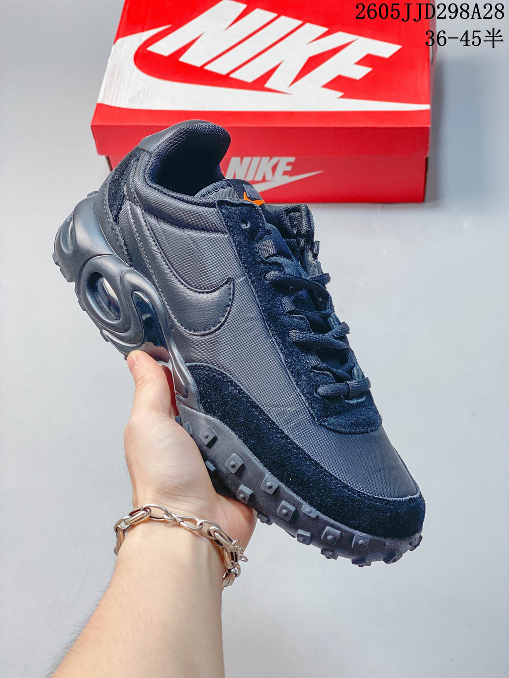 Angled side view of a dark gray low-top sneaker with a studded outsole