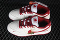 Pair of off-white and red Nike SB Dunk Low sneakers with horse-themed tongue graphics and a gold-tone charm