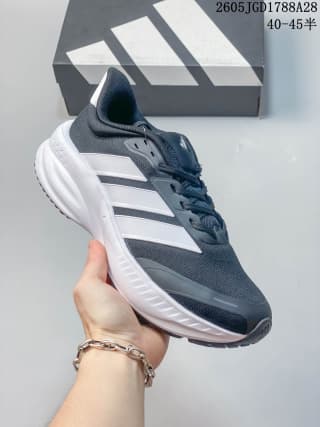 Dark gray training shoe with white side stripes and a light-colored sole; box label shows 40–45.
