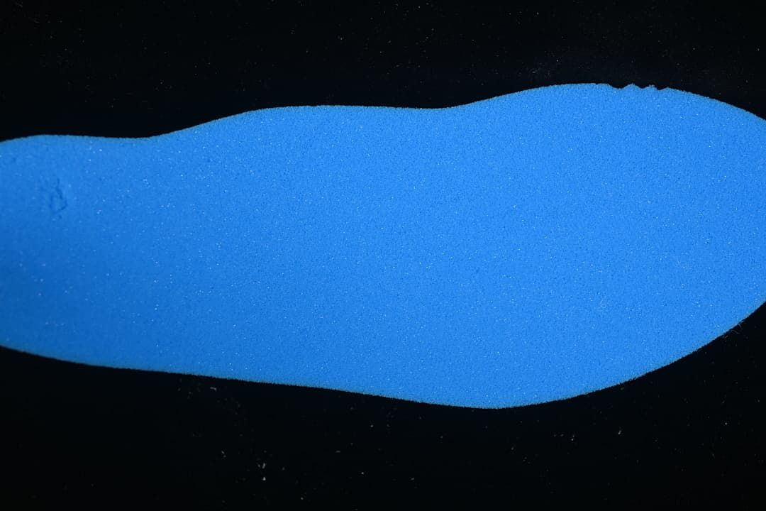 Blue shoe insole shown against a dark background