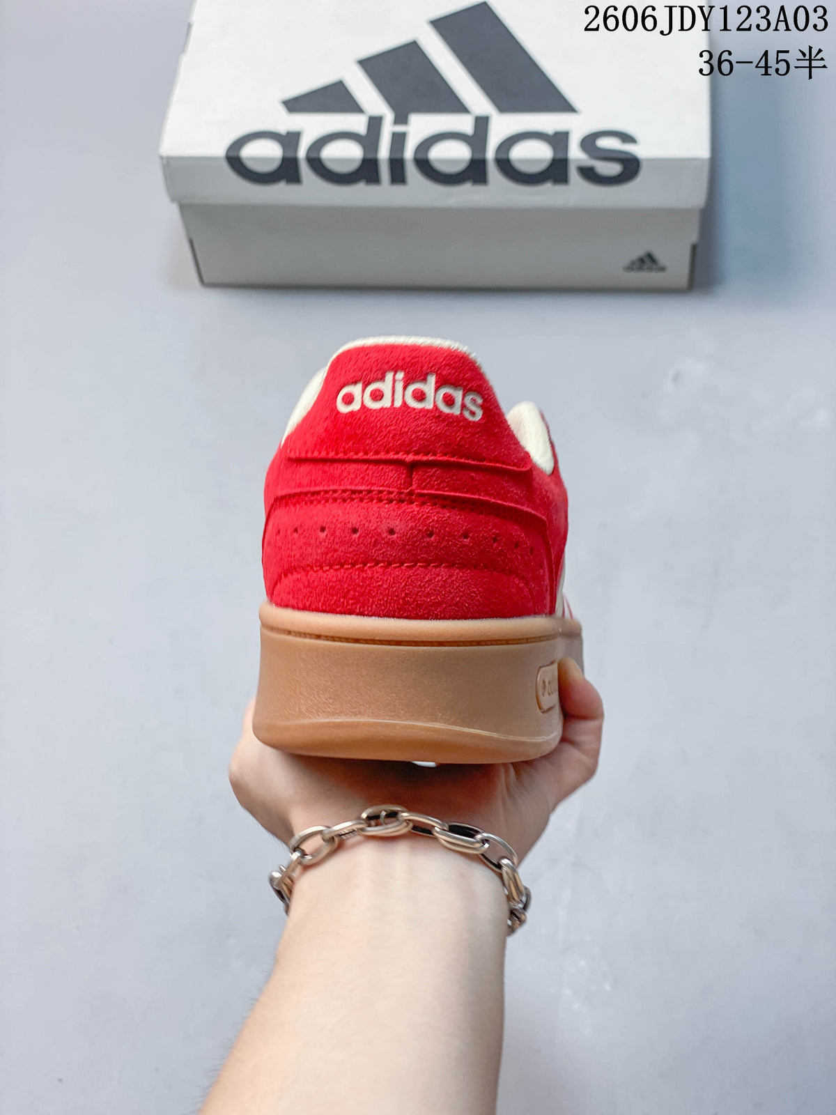 Rear view of the red sneaker with a gum-colored heel and Adidas branding