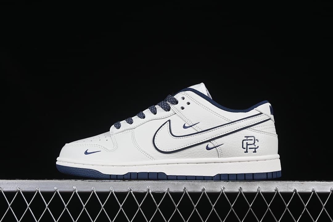 Side view of a white and navy Nike SB Dunk Low with Reigning Champ branding.