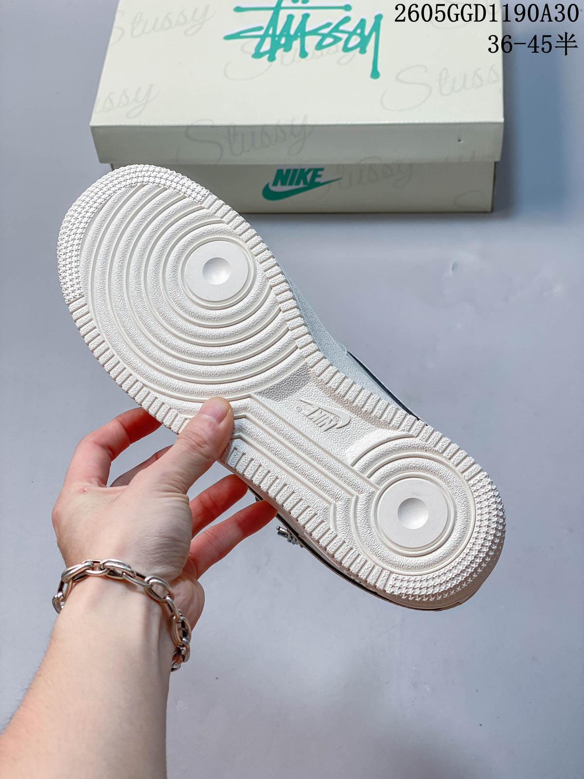 Underside of a white sneaker showing its circular-patterned rubber outsole