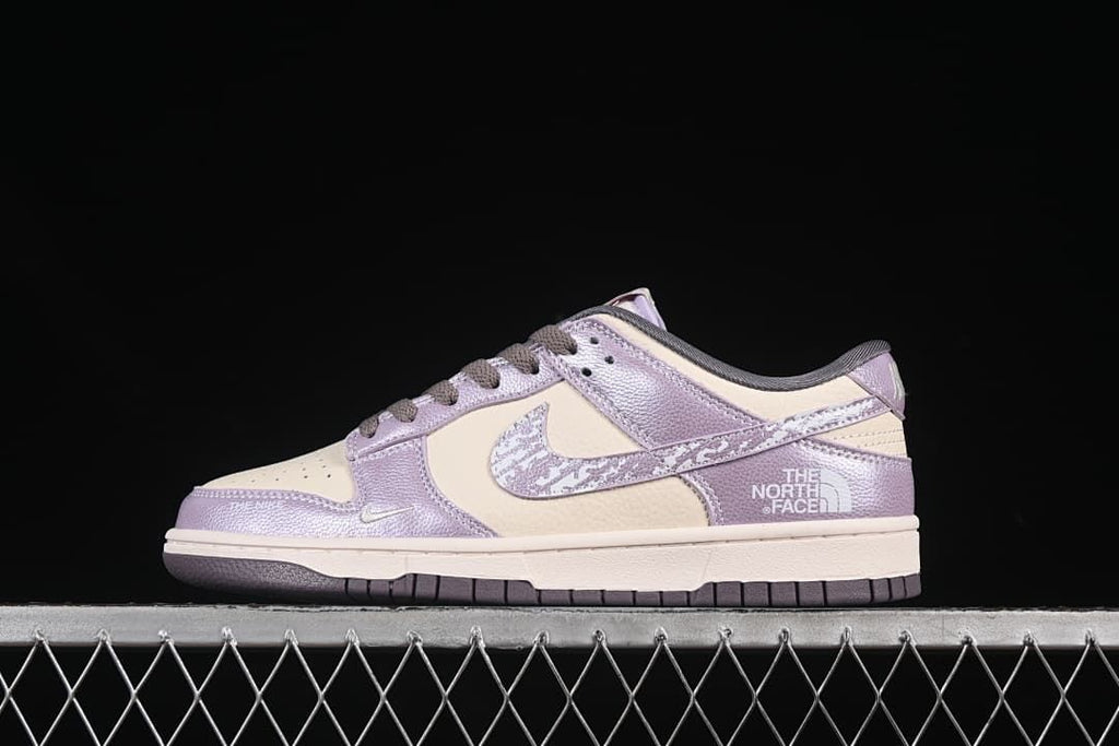 Side view of a cream and lavender-purple low-top sneaker with a patterned swoosh and dark outsole