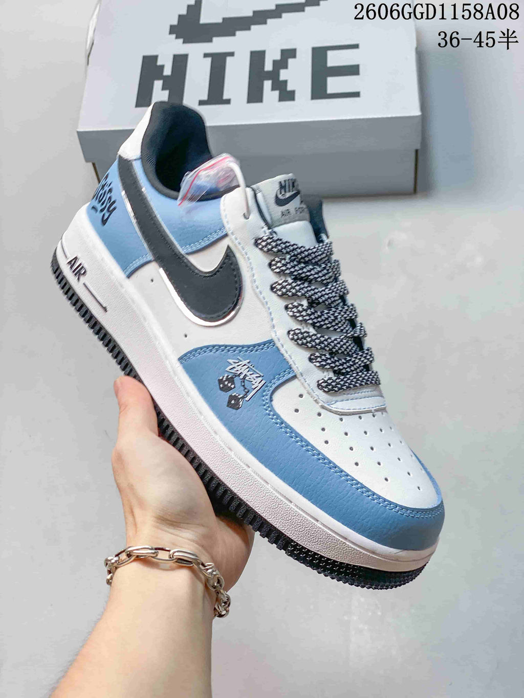Angled view of the sneaker's white and blue panels, dark side accent, and patterned laces