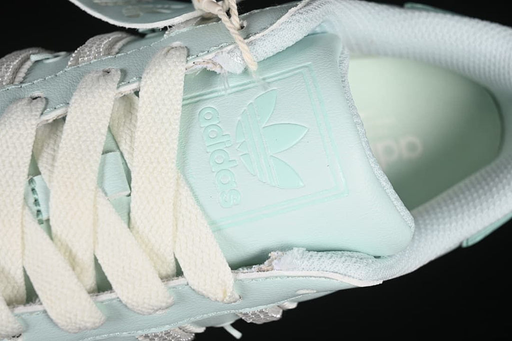 Close-up of the tongue with adidas trefoil branding and cream laces