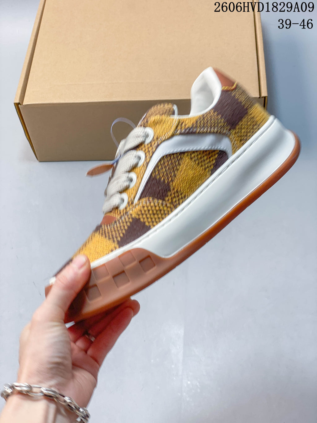Side profile of brown and yellow checkerboard low-top sneaker with white trim