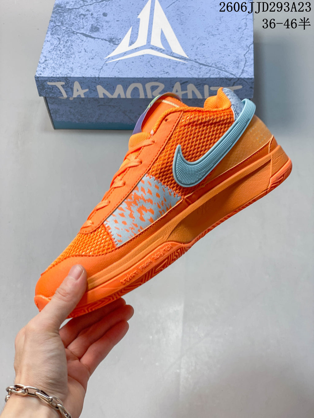 Side view of the orange Nike Ja 1 EP with blue accents and mesh panels.