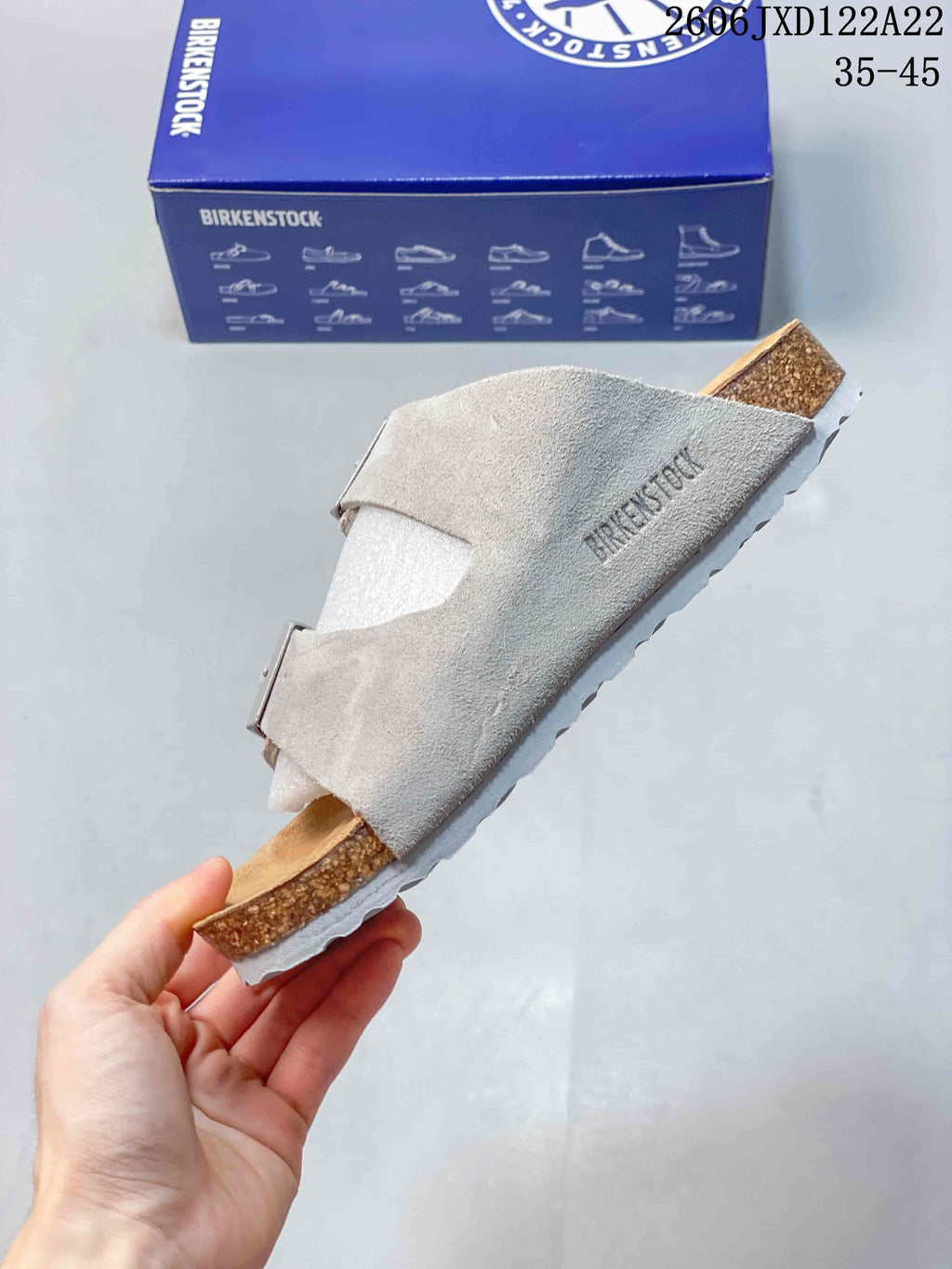 Side profile of a light taupe clog with two buckle straps and cork-look sidewall.