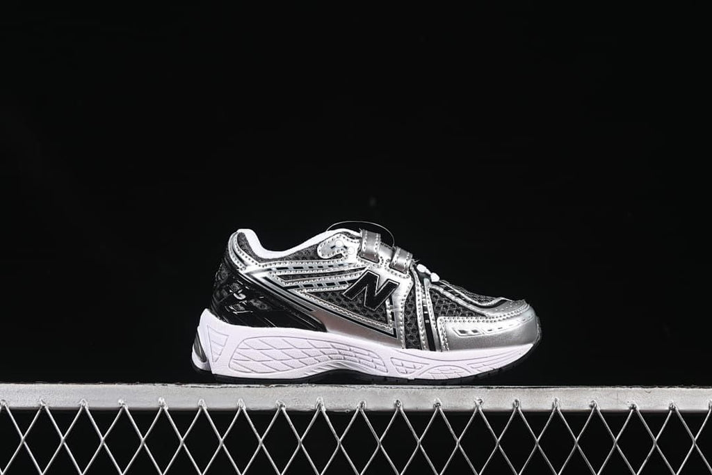 Side profile of a silver and black kids sneaker with hook-and-loop strap
