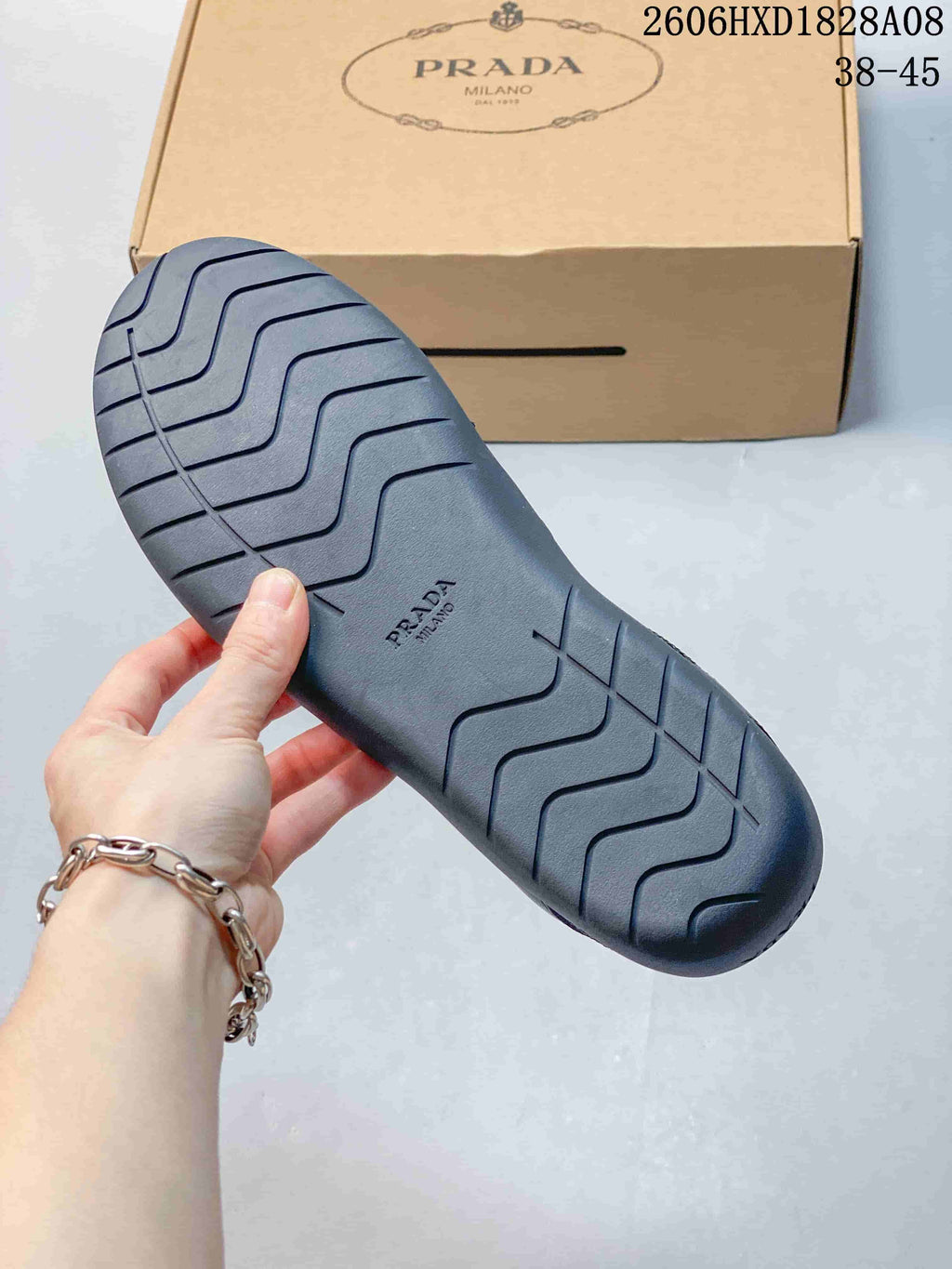 Underside of a sneaker showing molded tread and branding, with a shoebox behind it.