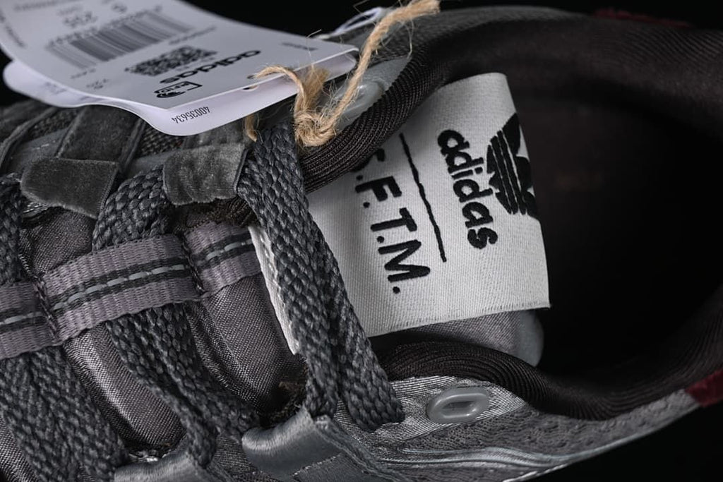 Close-up of the shoe tongue with adidas and S.F.T.M. branding.