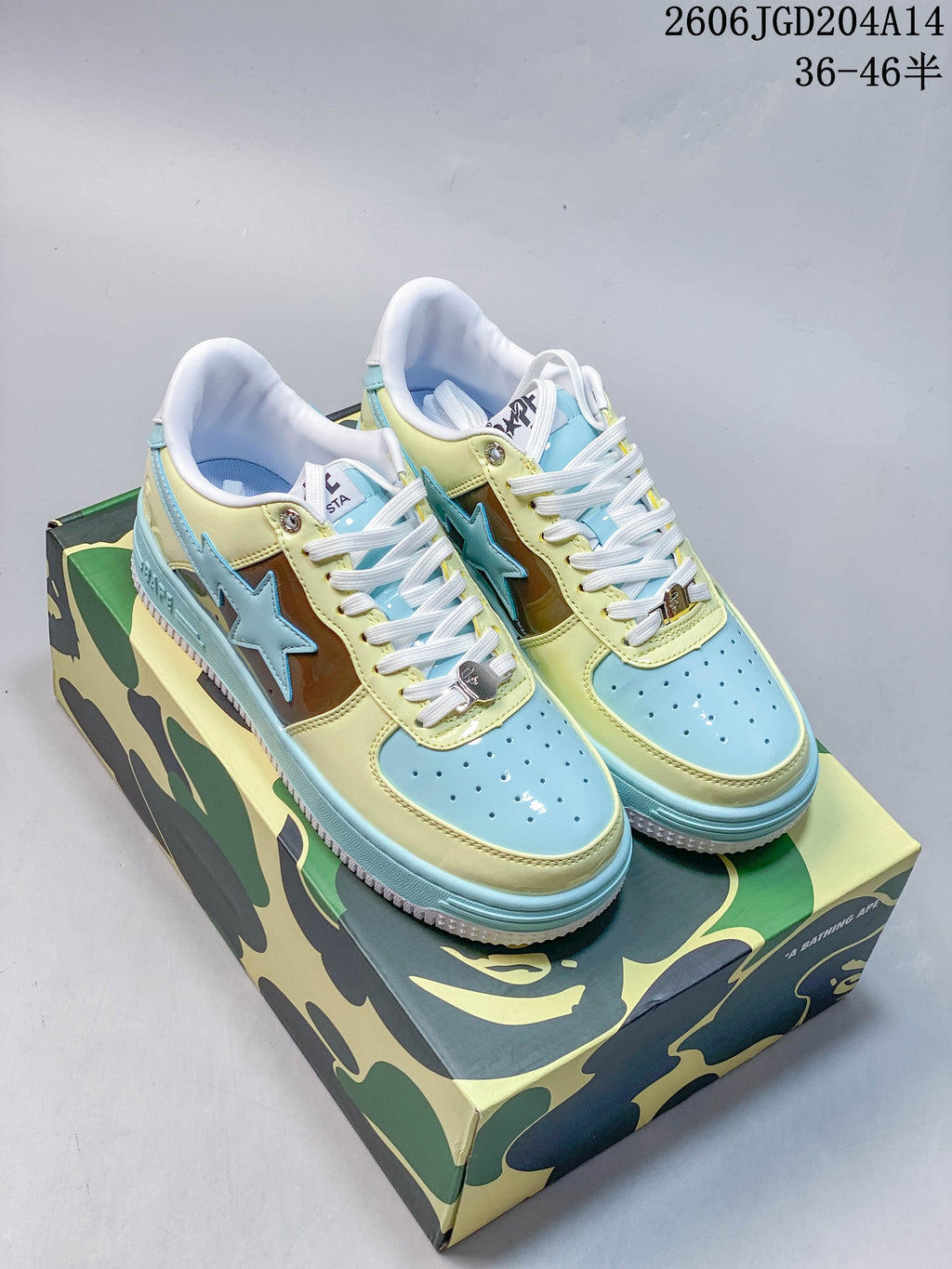 Pair of BAPE STA low-top sneakers in pale blue, yellow, and brown, shown on a camouflage-pattern box