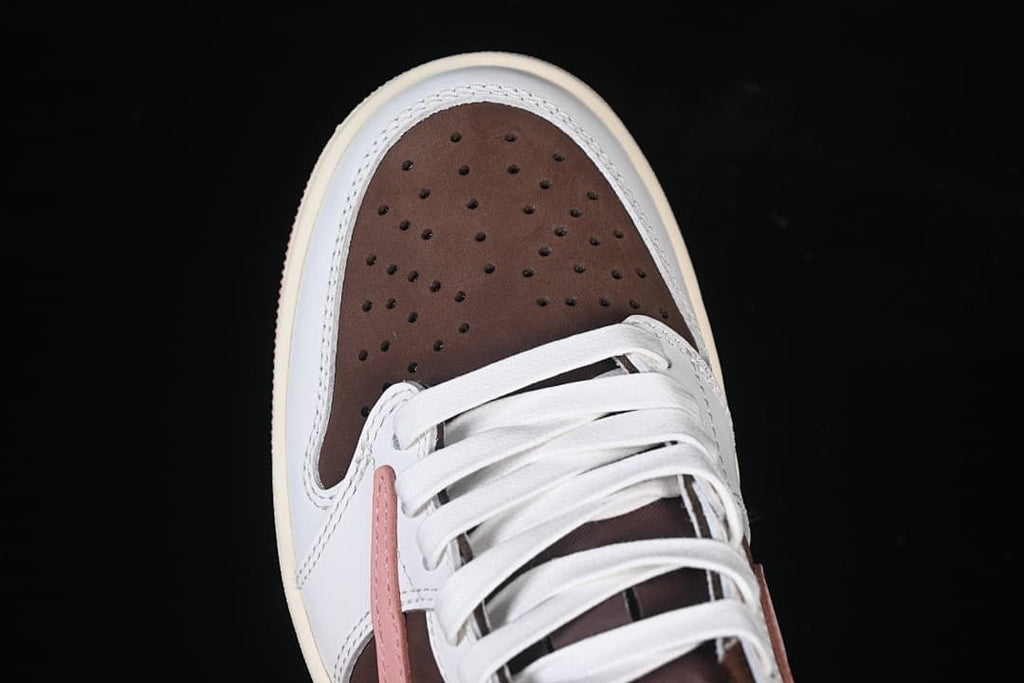 Top view of the perforated brown toe, white overlays, and white laces.
