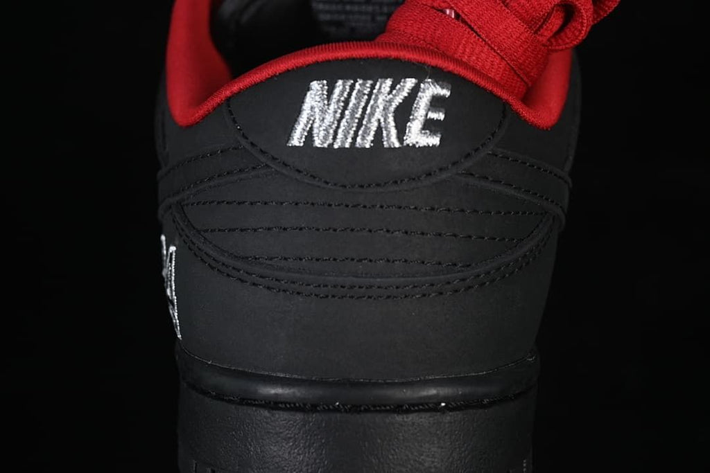 Rear view of the black shoe with embroidered Nike branding and red lining