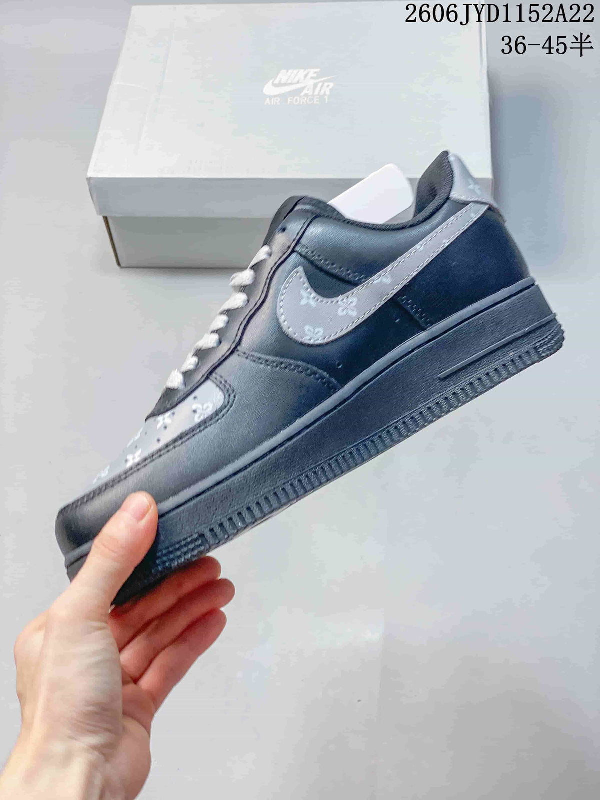 Side view of the gray sneaker with a patterned Swoosh and dark sole