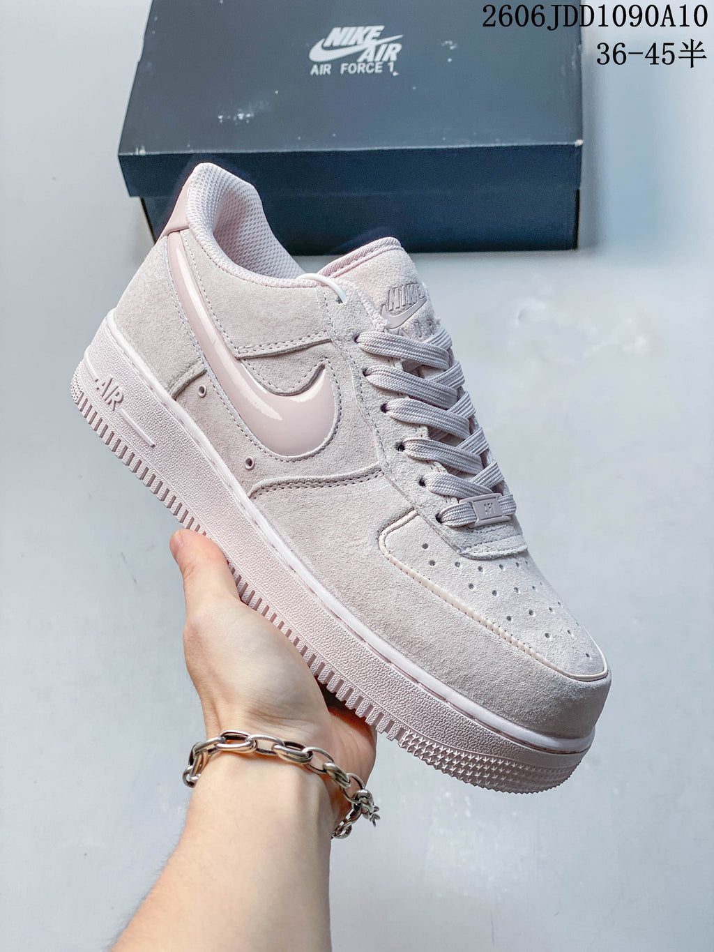 Pale pink Nike Air Force 1 sneaker shown from the side.
