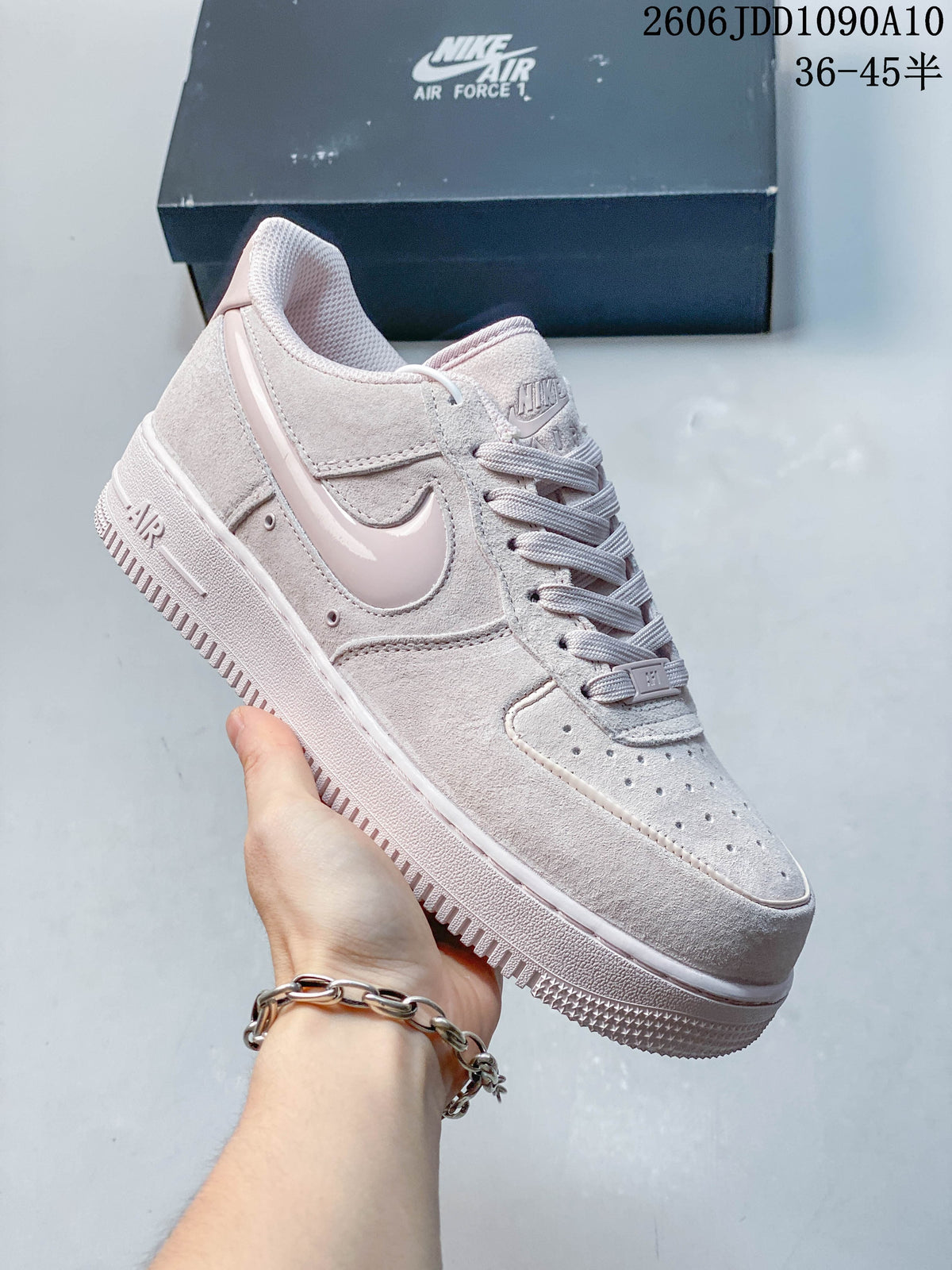 Pale pink Nike Air Force 1 sneaker shown from the side.