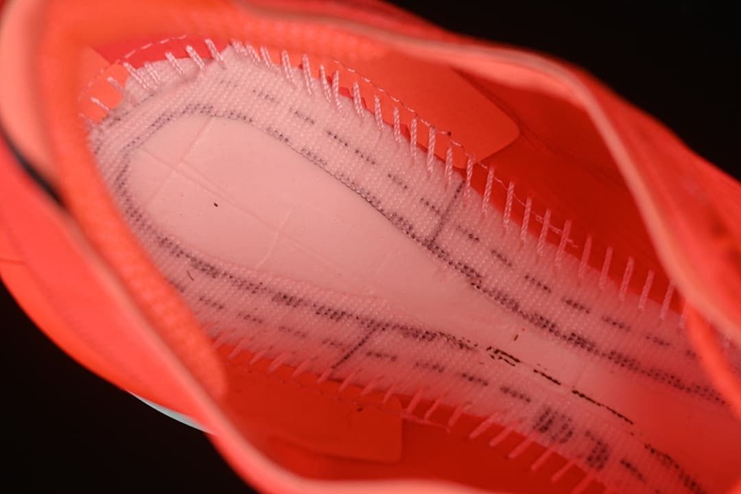 Close-up view inside the coral-red running shoe.