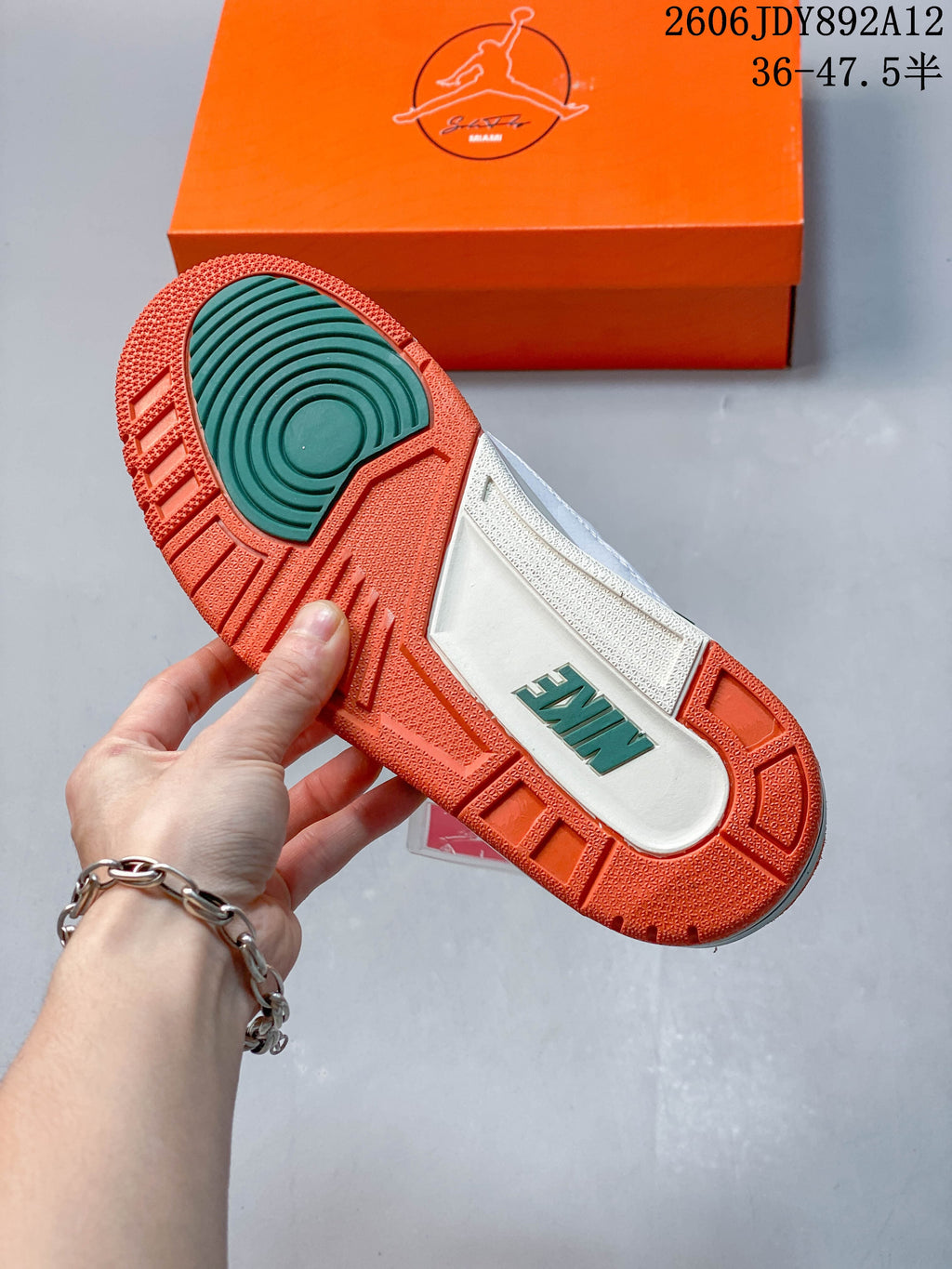 Outsole view showing orange and green sections on a Jordan Air Jordan 3 Retro sneaker