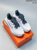 Pair of white and dark-accented Nike Air Zoom Winflo 12 running shoes on an orange box