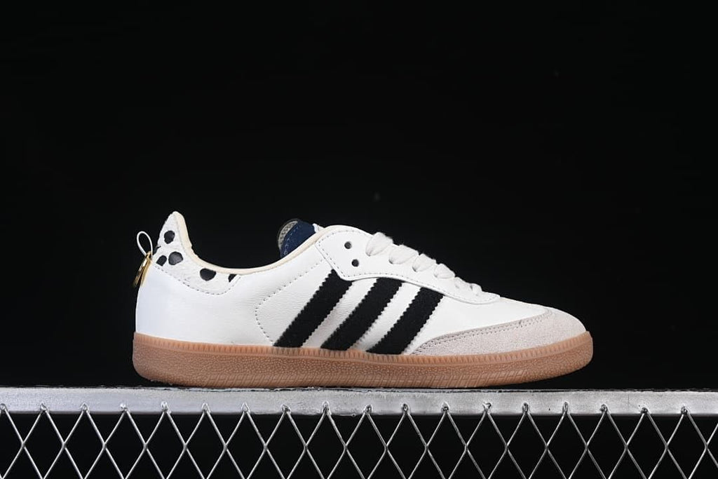 Side profile of a white low-top sneaker with black stripes, gray toe overlay, and gum outsole.