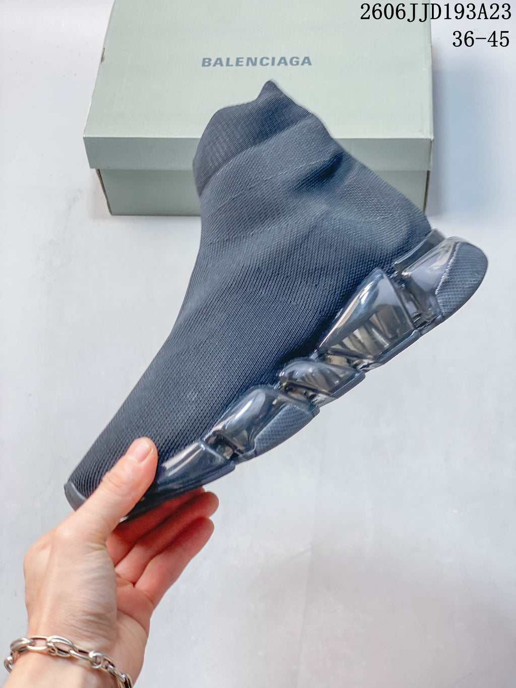 Side profile of a gray sock-style sneaker with transparent sole sections
