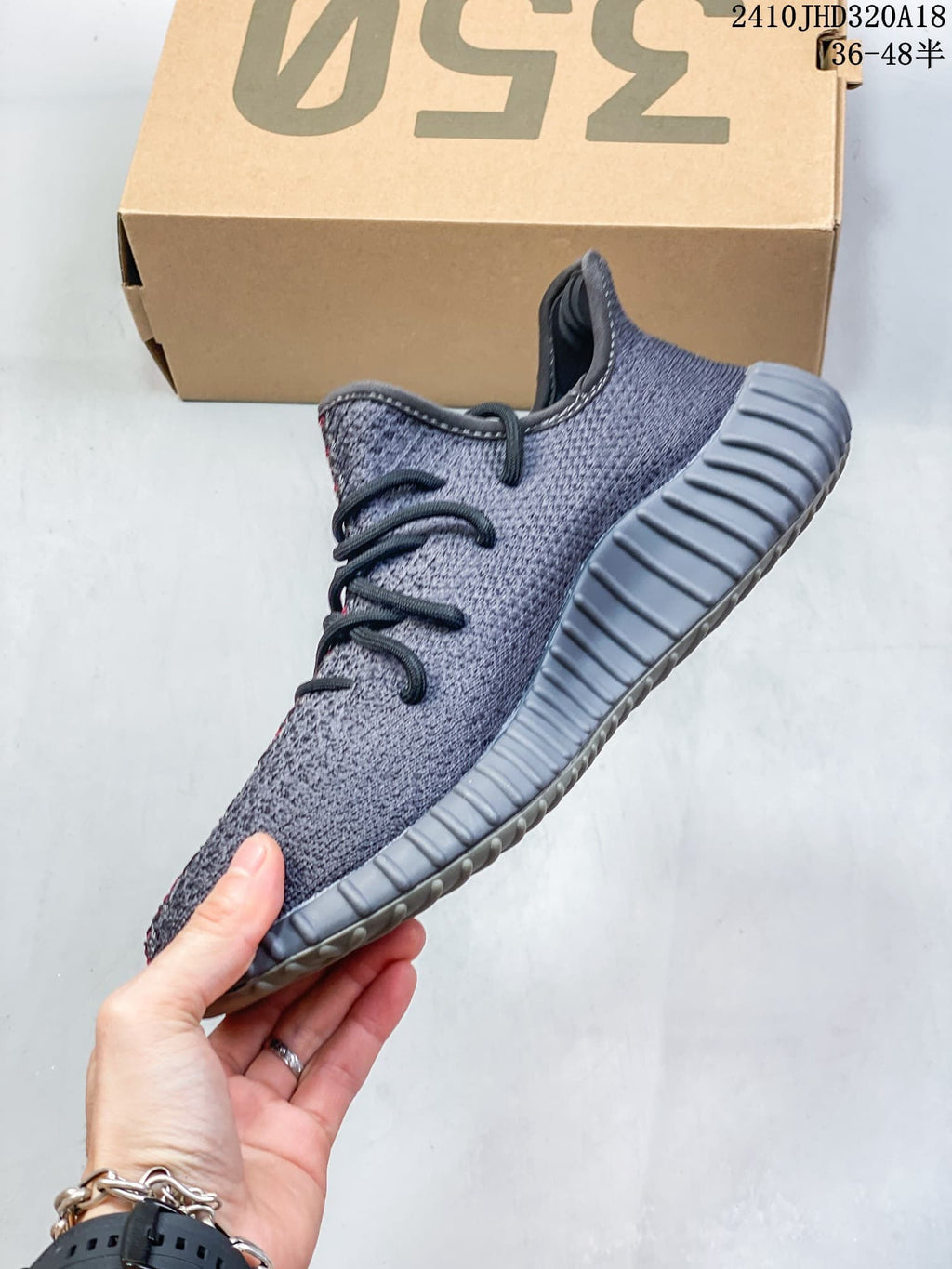 Side view of a gray knit-style sneaker with black laces and a ribbed sole