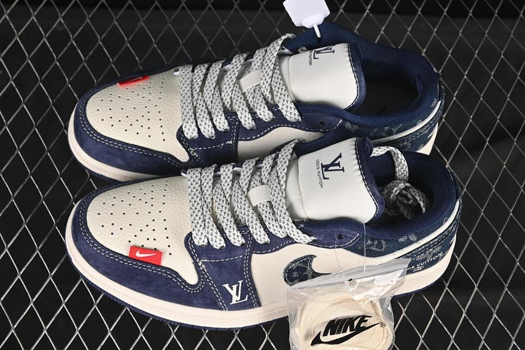Top view of a pair of navy and off-white low-top sneakers with patterned laces and spare laces
