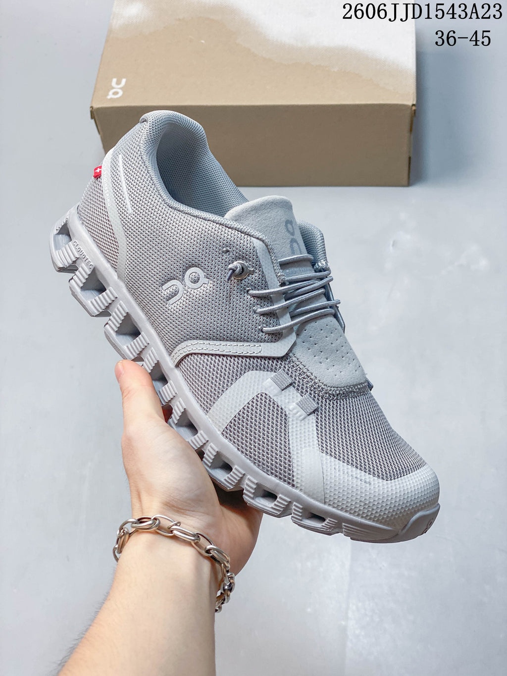 Angled side view of the grey sneaker showing its mesh-look panels and sole.