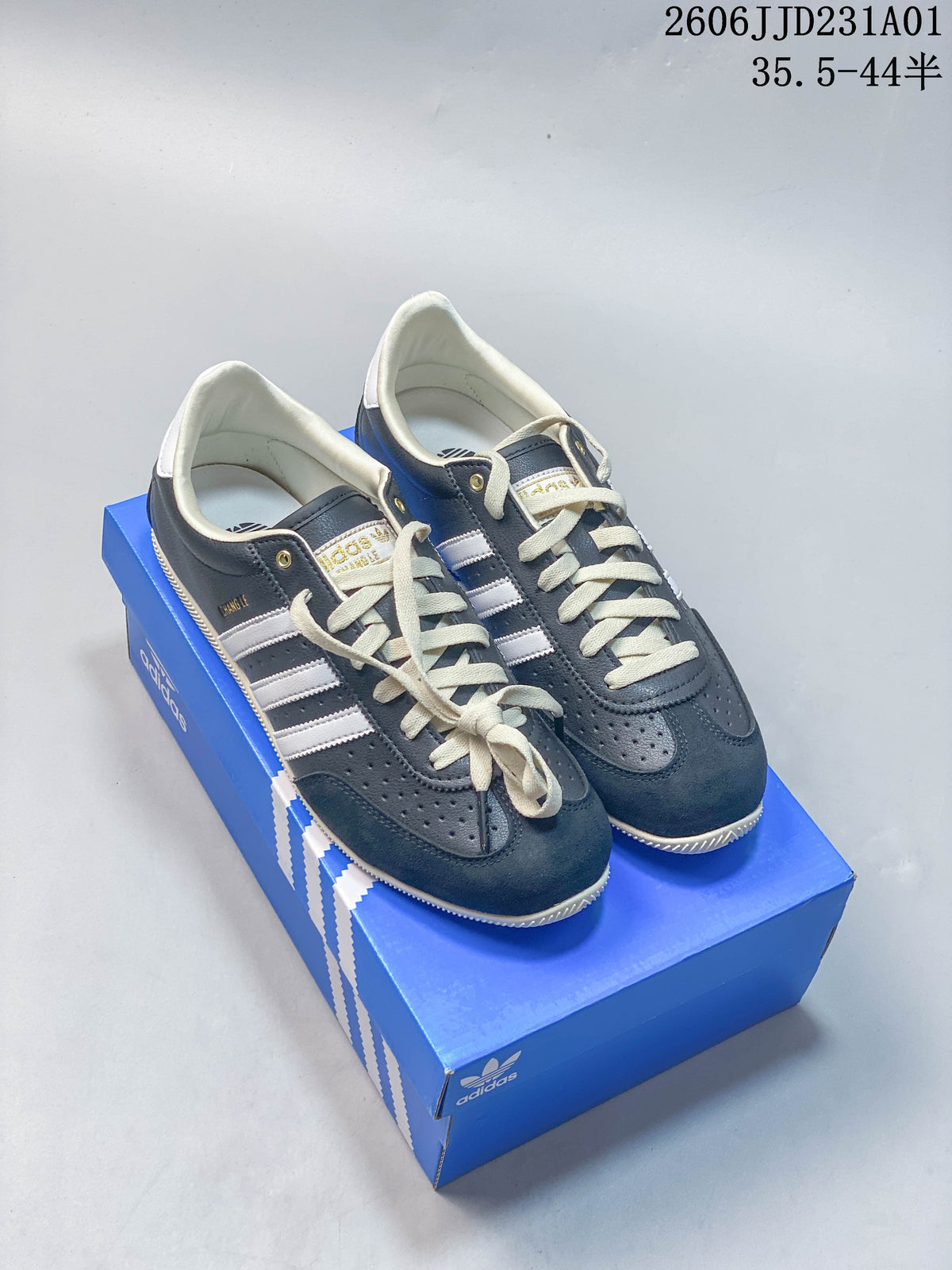 Pair of navy Adidas Changle low-top sneakers with light-colored stripes and laces.