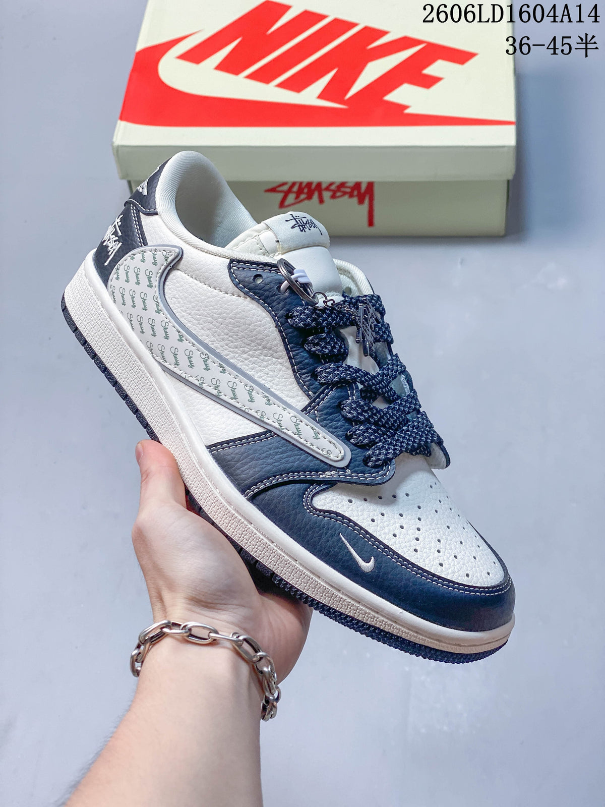 Side view of a white and navy sneaker with repeated-script side graphics and a metal charm