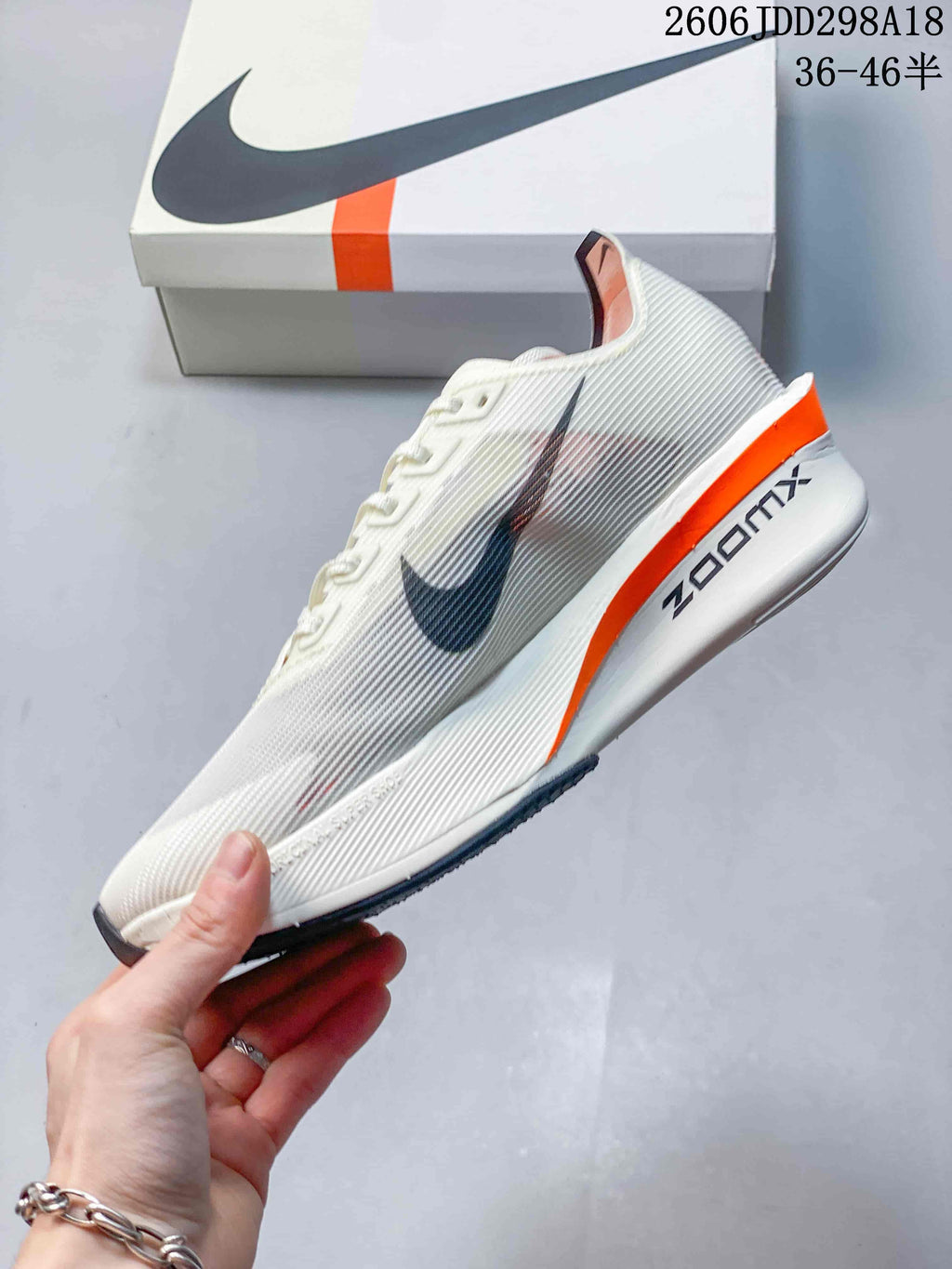 Side view of an off-white Nike Vaporfly shoe with dark Swoosh detail and orange midsole accent