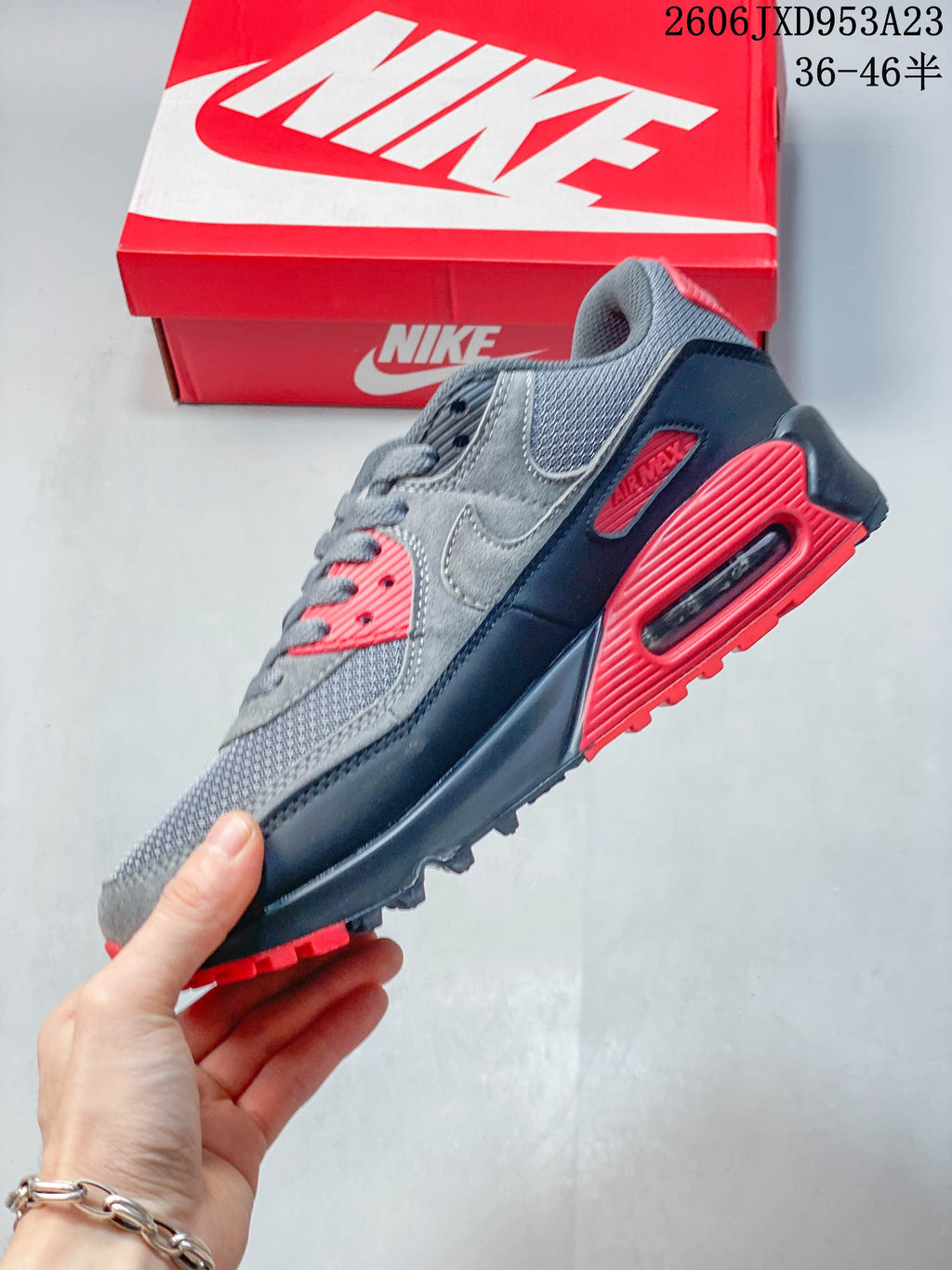 Side view of a gray and red Nike Air Max 90 with a visible heel Air unit