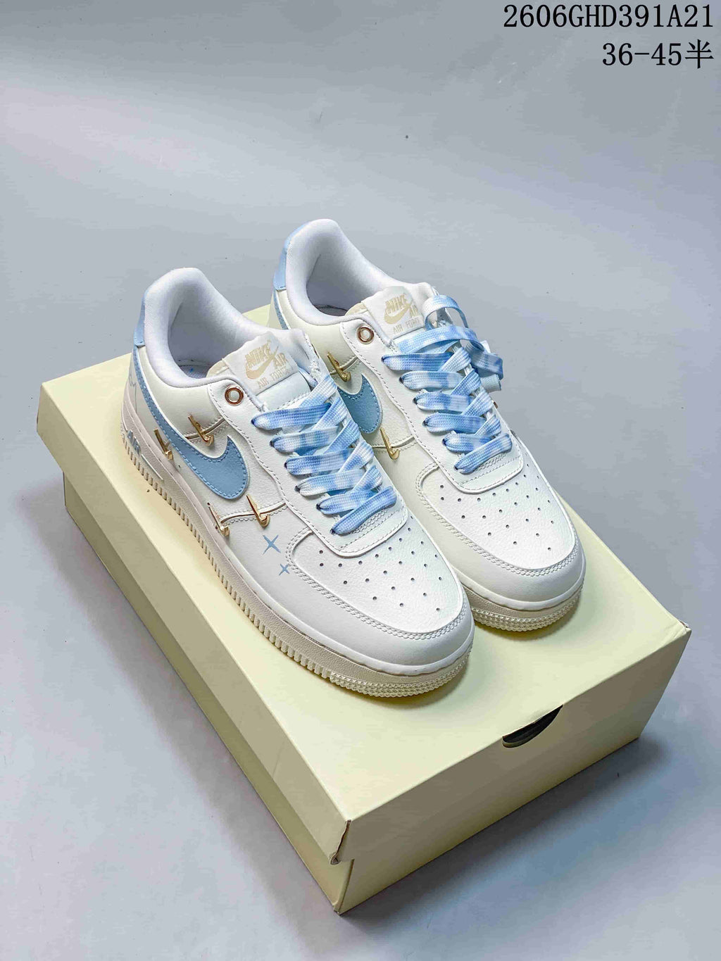 Pair of white and light blue Nike Air Force 1 Low sneakers with gold-tone side details