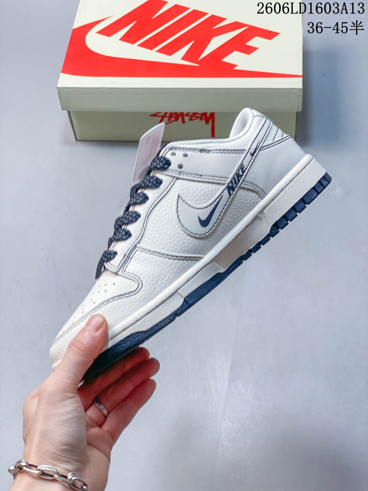 Side view of the white low-top sneaker with navy accents