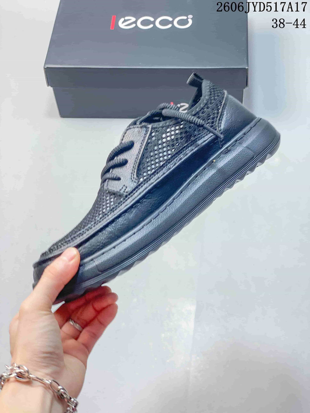 Side view of a dark gray ECCO lace-up sneaker with mesh-look panels; image text states sizes 38–44.