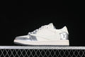 Side view of a silver and white low-top sneaker with patterned overlays.