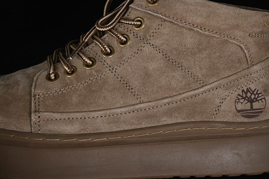 Close-up of the khaki boot's side panels, logo, eyelets, and laces