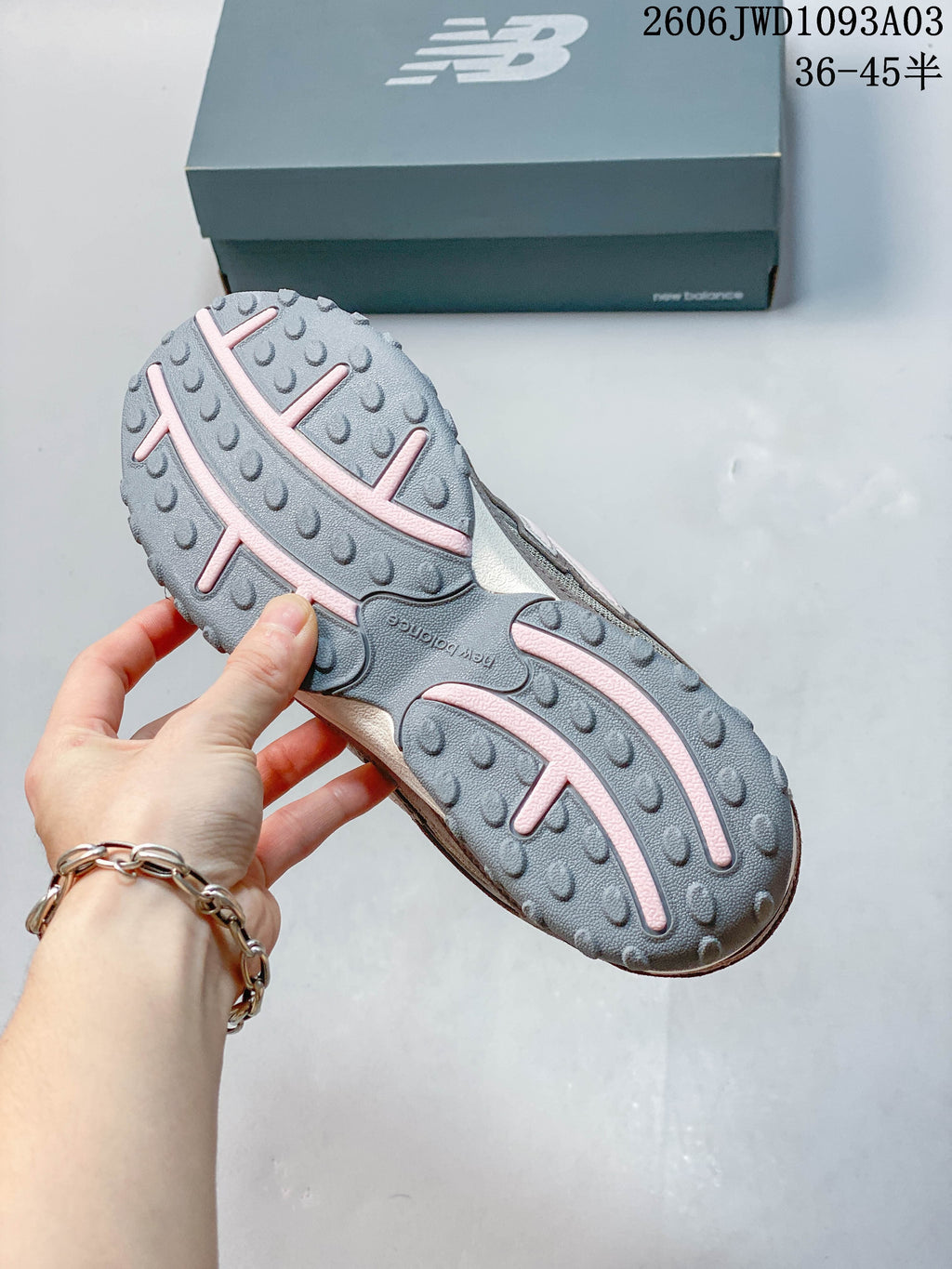 Close-up of the textured gray outsole with pale pink design details