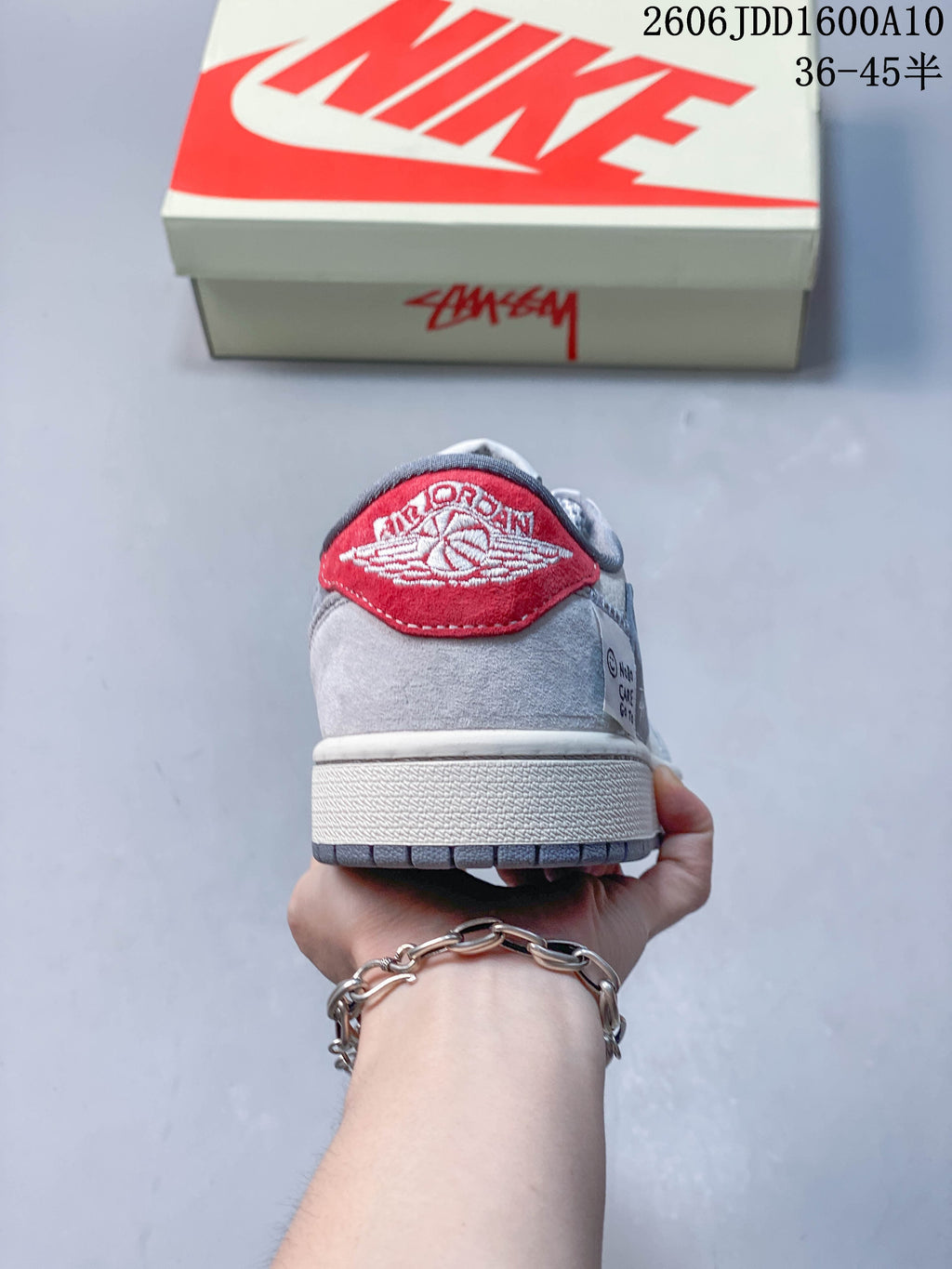 Rear view showing a red heel tab and grey upper.