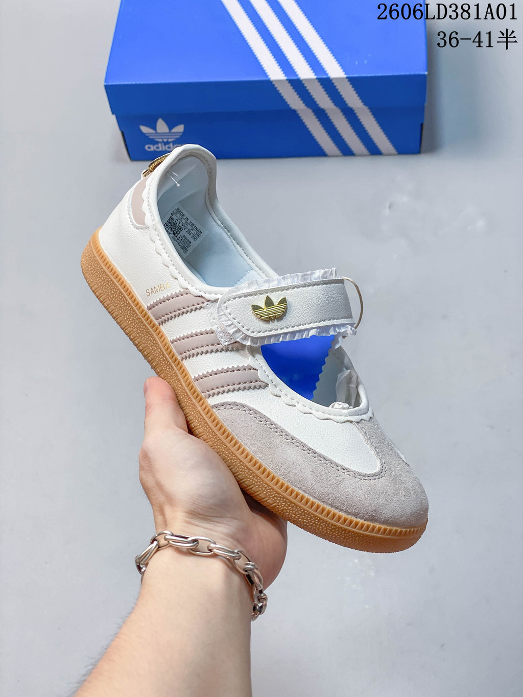 Angled view of an Adidas Samba Jane sneaker showing the strap, contrast stripes, and pale toe overlay.