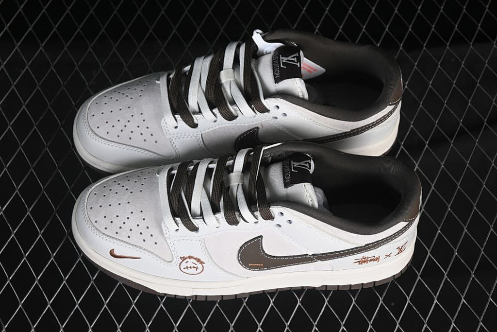Overhead view of a pair of white and light gray low-top sneakers with contrasting laces and perforated toe boxes.
