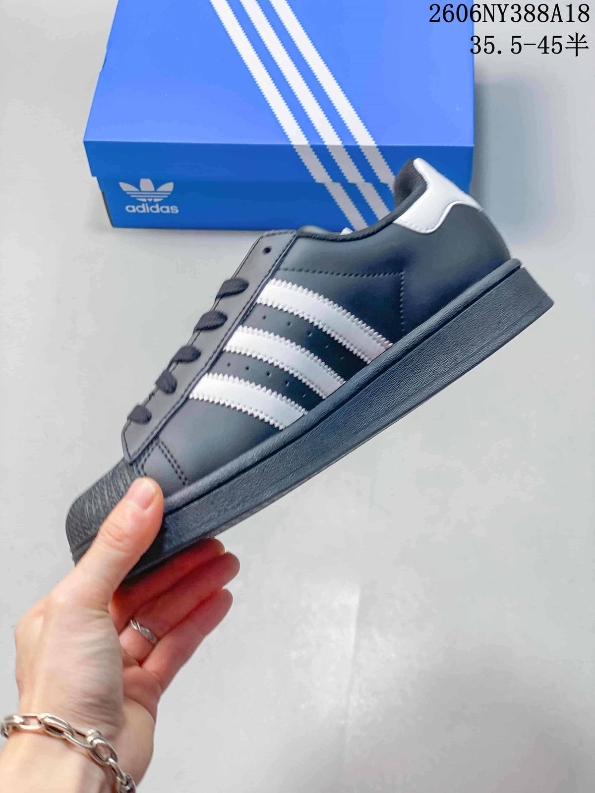 Side view of a dark gray low-top sneaker with white stripes and a textured shell toe; image overlay reads “35.5–45.5.”
