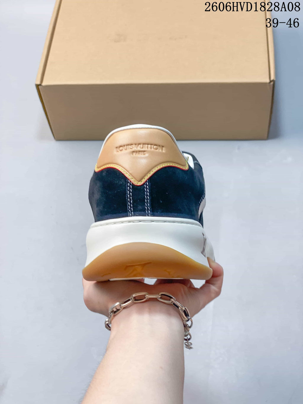 Rear view of navy sneaker with tan heel accent and white midsole