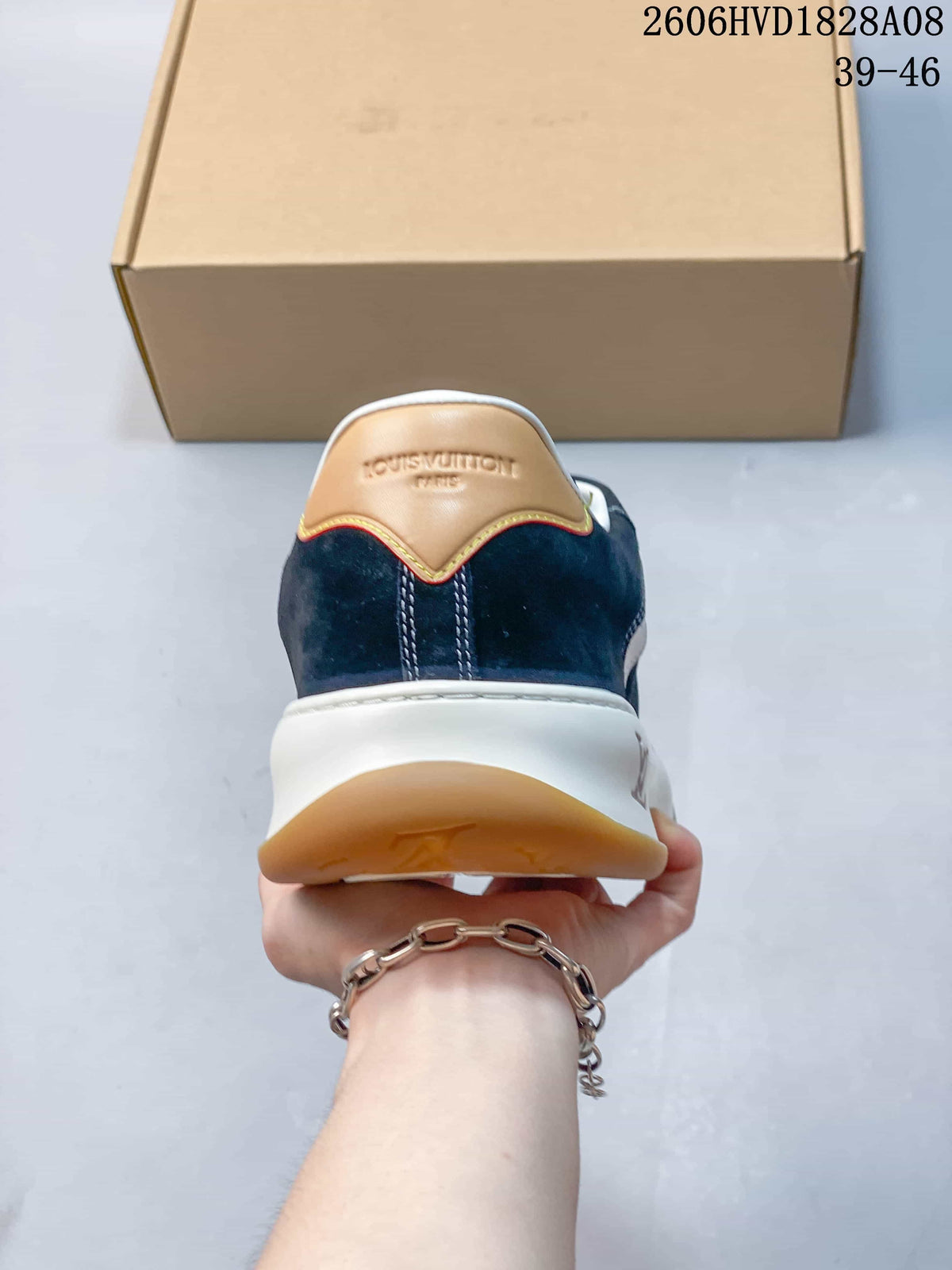 Rear view of navy sneaker with tan heel accent and white midsole