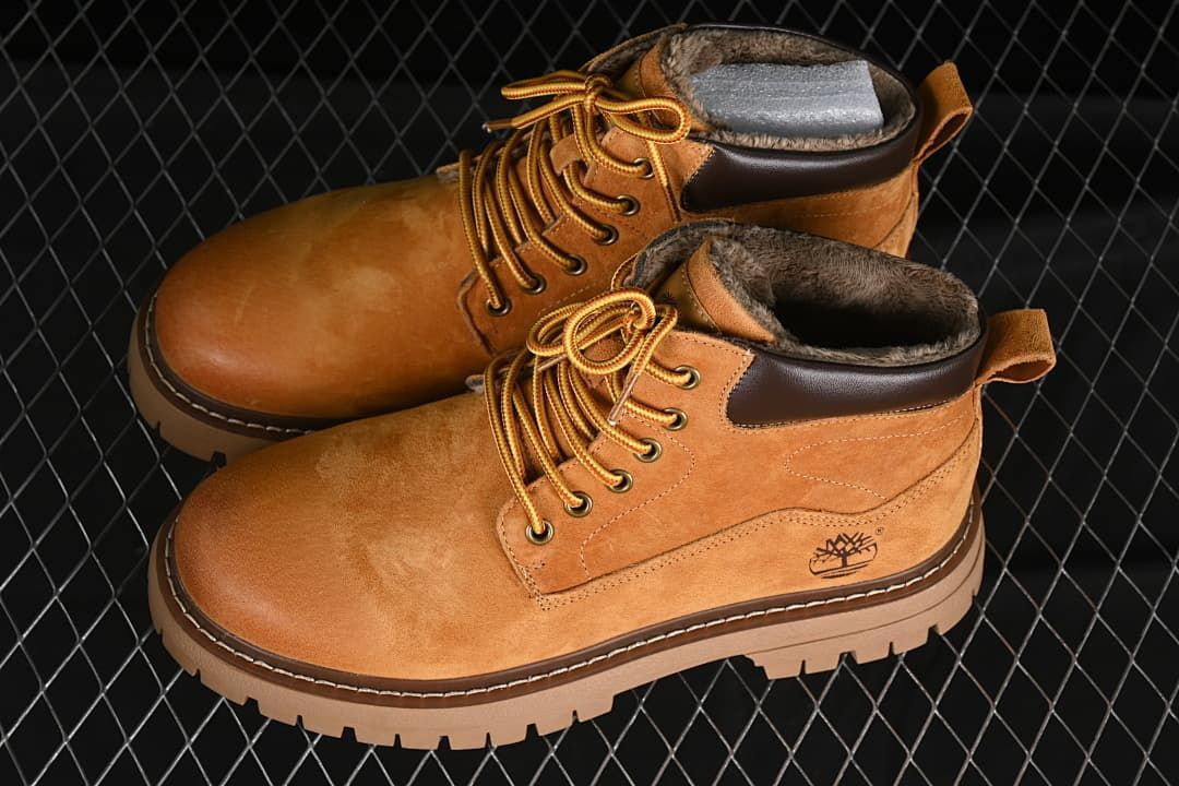 Pair of yellow-brown mid-top boots with plush lining and lugged soles.