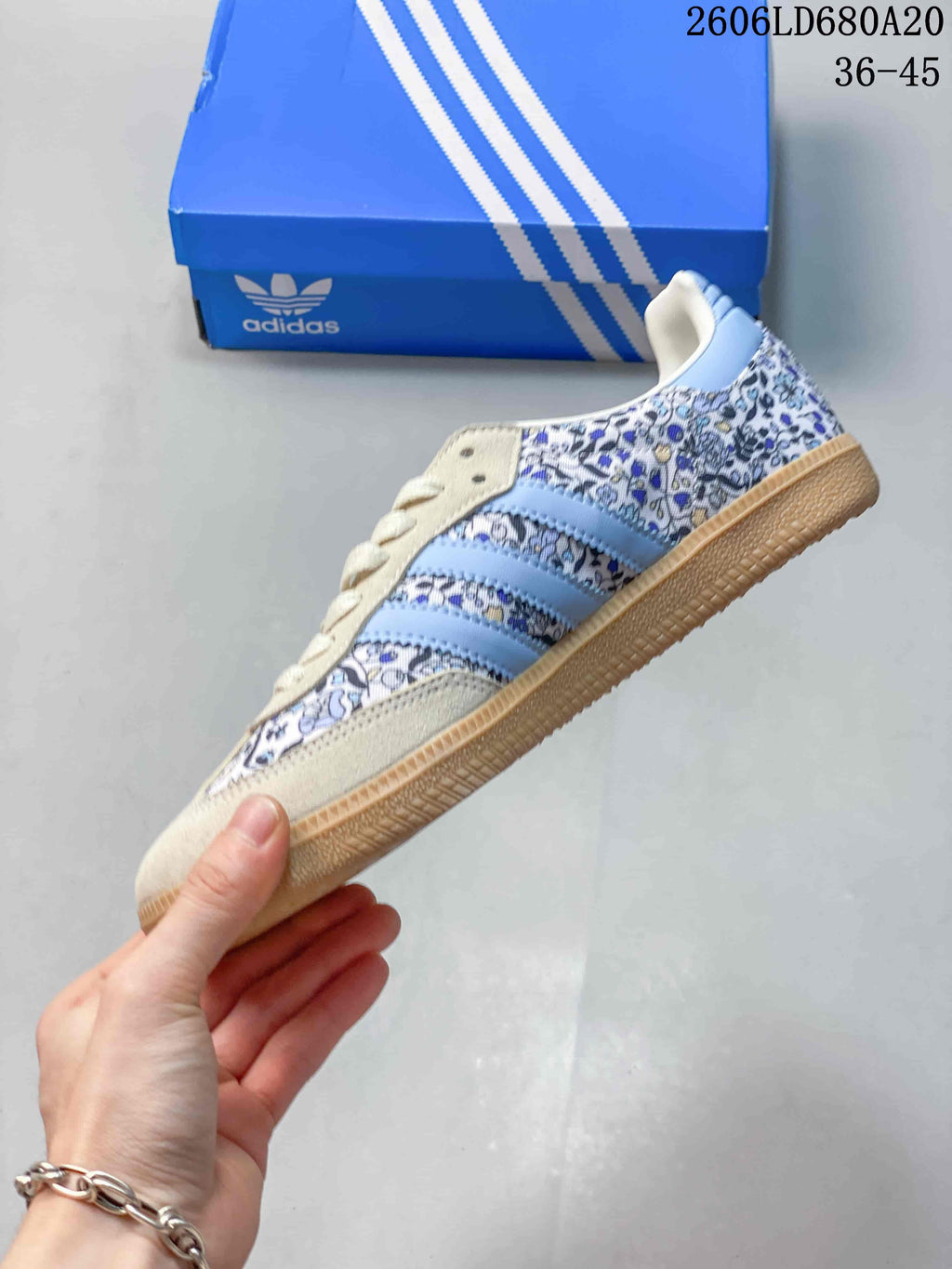 Side view of the low-top sneaker showing floral panels, light blue stripes, cream overlays, and a gum-colored sole.