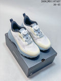 Pair of white DESCENTE low-top sneakers with pale blue-gray and cream accents, shown on a shoe box.