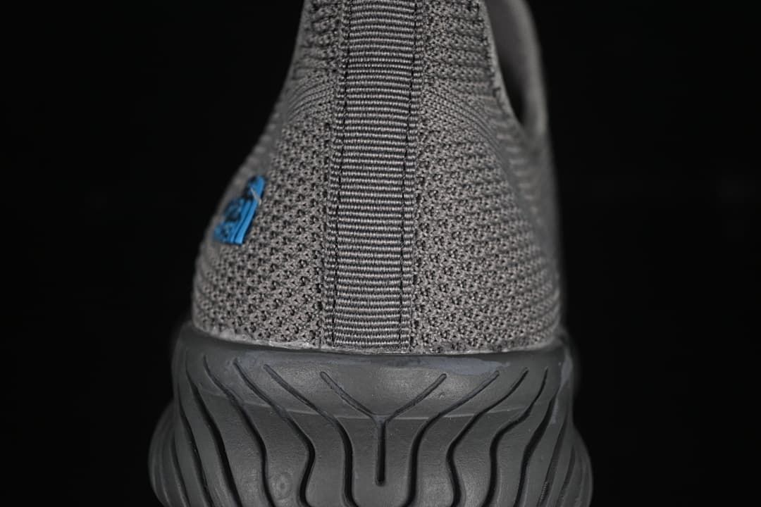 Rear view of the gray shoe with heel pull tab and grooved outsole